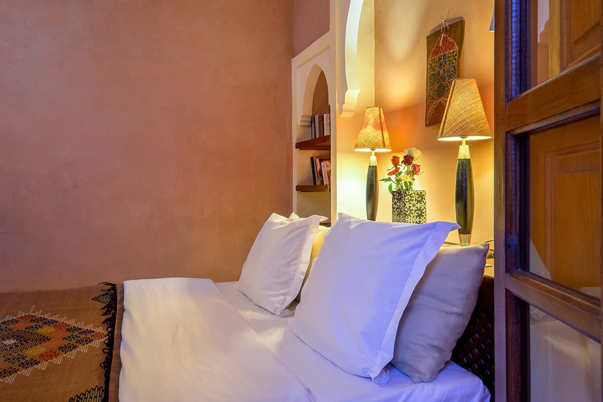 Riad Sable Chaud Marrakech — Cour intérieure luxueuse avec végétation et zellige traditionnel